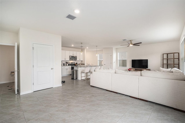 living room featuring a ceiling fan, visible vents, and recessed lighting