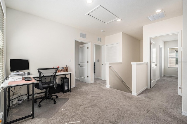 office space with baseboards, carpet, visible vents, and attic access