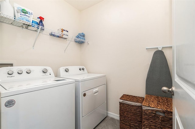 laundry room featuring light tile patterned floors, laundry area, washing machine and clothes dryer, and baseboards