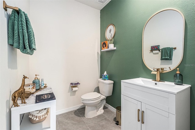 half bath featuring toilet, visible vents, vanity, baseboards, and tile patterned floors