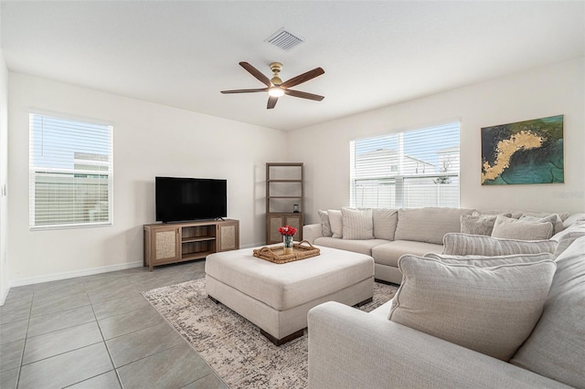 living room featuring baseboards, light tile patterned flooring, visible vents, and a ceiling fan