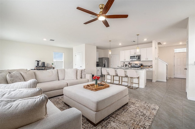 living room featuring recessed lighting, visible vents, a ceiling fan, light tile patterned flooring, and baseboards