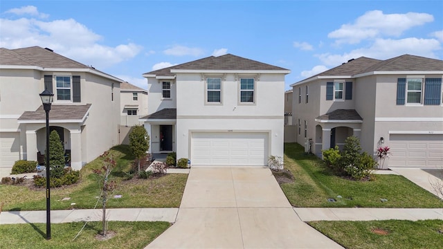 traditional-style home with a garage, a front yard, concrete driveway, and stucco siding