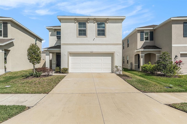 view of front of property featuring a front yard, driveway, an attached garage, and stucco siding