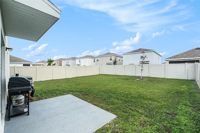 view of yard featuring a patio area, a fenced backyard, and a residential view