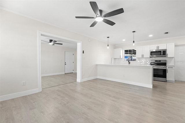 kitchen with white cabinetry, pendant lighting, stainless steel appliances, kitchen peninsula, and decorative backsplash