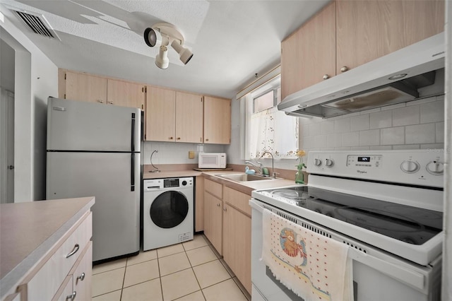 2113 Canal Dr Unit B2, Bradenton, FL 34207 - kitchen with washer / dryer, white appliances, light brown cabinetry, under cabinet range hood, and backsplash