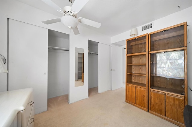 2113 Canal Dr Unit B2, Bradenton, FL 34207 - unfurnished bedroom featuring light carpet, two closets, and ceiling fan