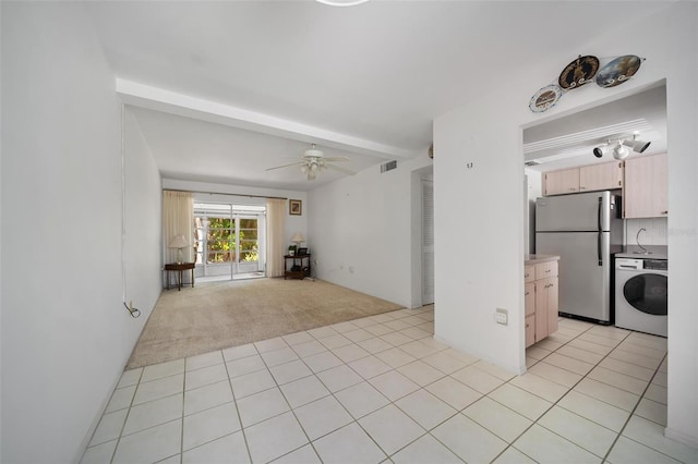 2113 Canal Dr Unit B2, Bradenton, FL 34207 - unfurnished living room featuring washer / dryer, light carpet, ceiling fan, and light tile patterned floors