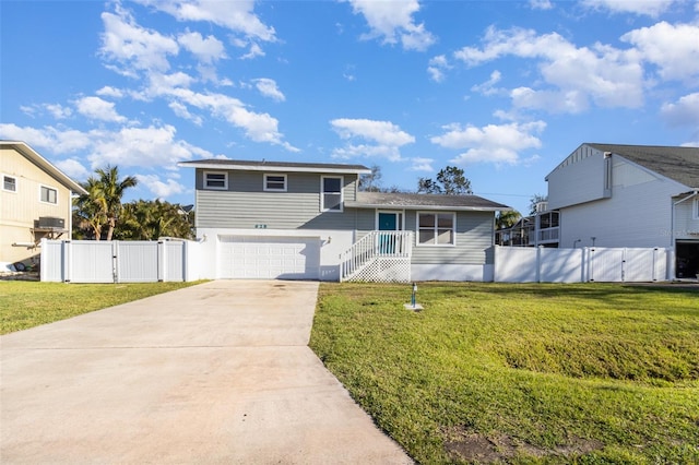 split level home featuring a front yard, a gate, fence, an attached garage, and concrete driveway