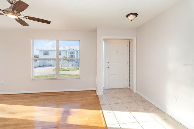 entryway with light tile patterned floors, baseboards, and a ceiling fan