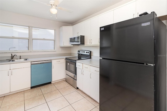 kitchen with a sink, stainless steel appliances, white cabinets, light countertops, and light tile patterned floors