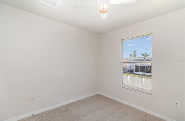 carpeted empty room featuring baseboards and ceiling fan