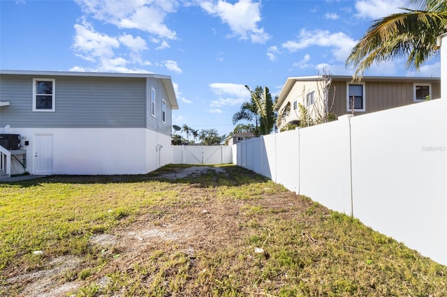 view of yard with central AC unit and a fenced backyard