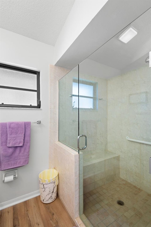 bathroom featuring hardwood / wood-style flooring, a textured ceiling, and walk in shower