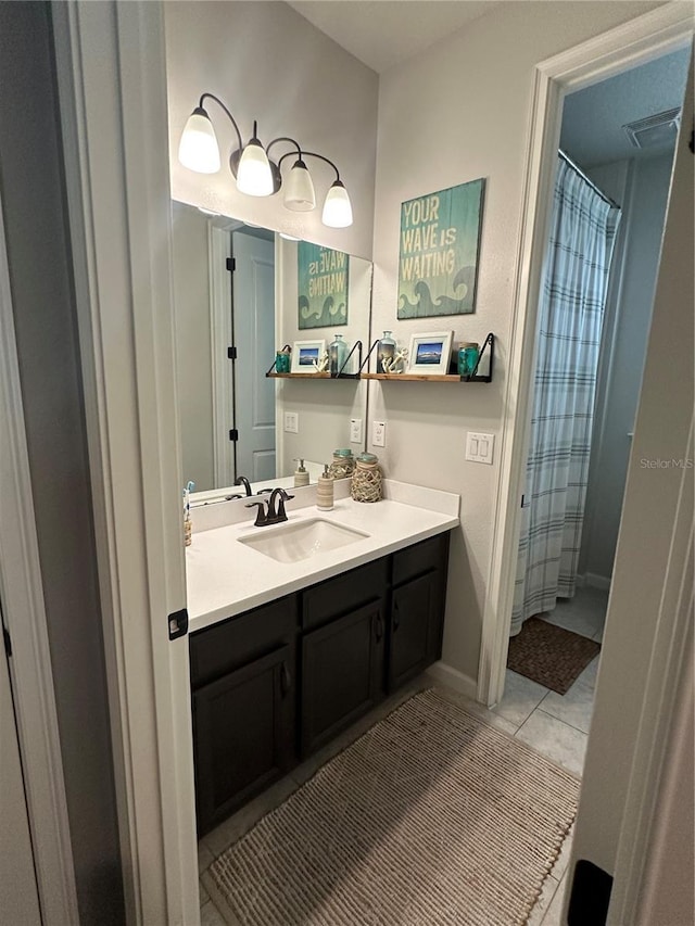 bathroom with baseboards, visible vents, vanity, and tile patterned floors