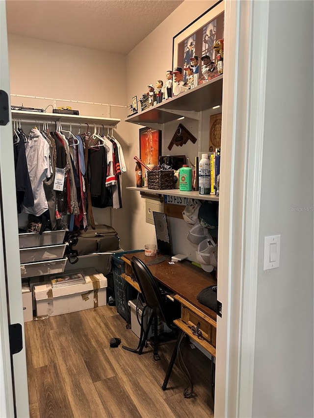 walk in closet with wood finished floors