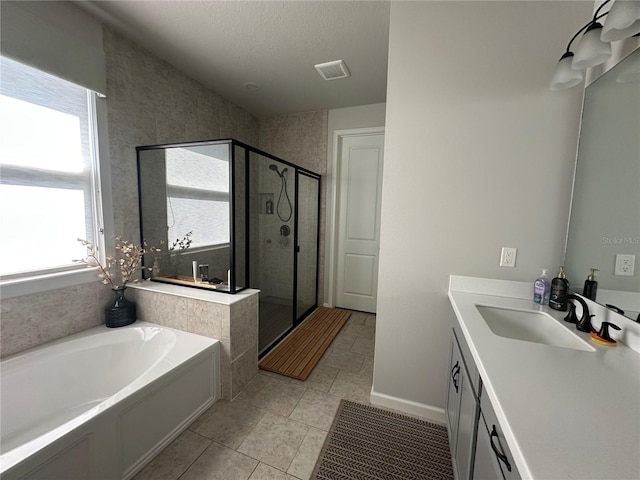 full bathroom with a textured ceiling, vanity, visible vents, a bath, and a stall shower