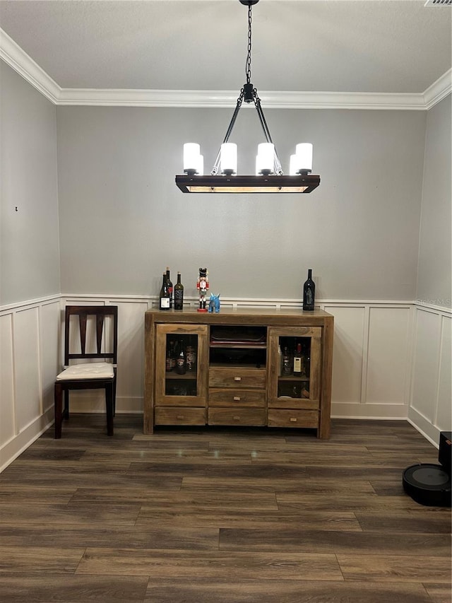 bar featuring dark wood-style floors, pendant lighting, crown molding, and an inviting chandelier