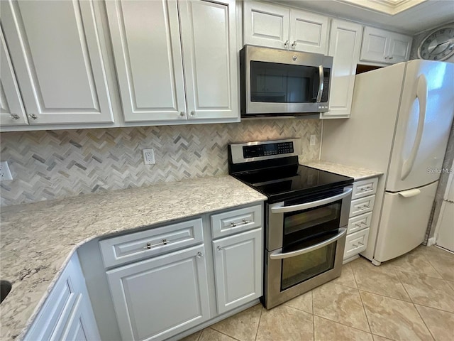 kitchen featuring light tile patterned floors, stainless steel appliances, backsplash, and white cabinets