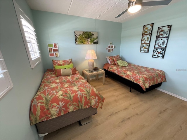 bedroom with baseboards, a ceiling fan, and wood finished floors