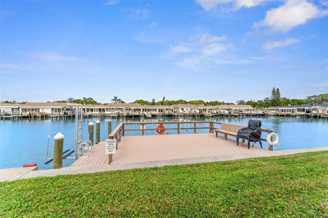 view of dock featuring a lawn and a water view