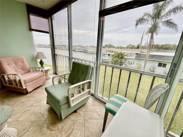 sunroom featuring a water view