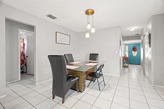 dining space with baseboards, light tile patterned flooring, visible vents, and a textured ceiling