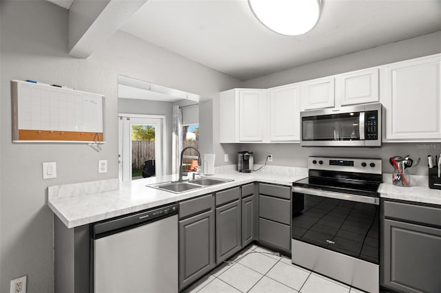 kitchen featuring gray cabinetry, light countertops, appliances with stainless steel finishes, and white cabinets