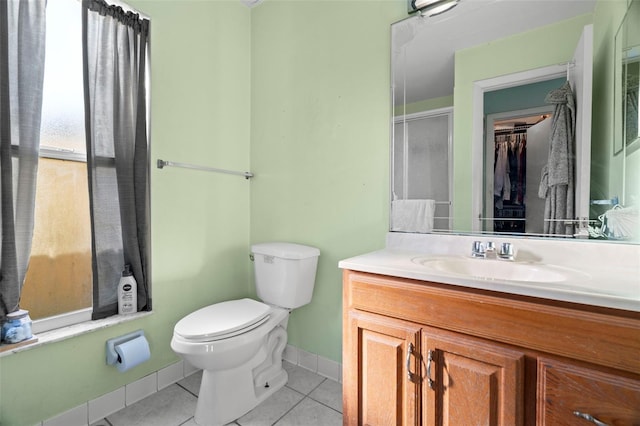 bathroom with toilet, washtub / shower combination, vanity, baseboards, and tile patterned floors