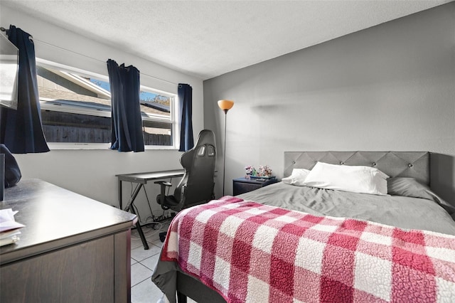 bedroom featuring a textured ceiling and light tile patterned floors