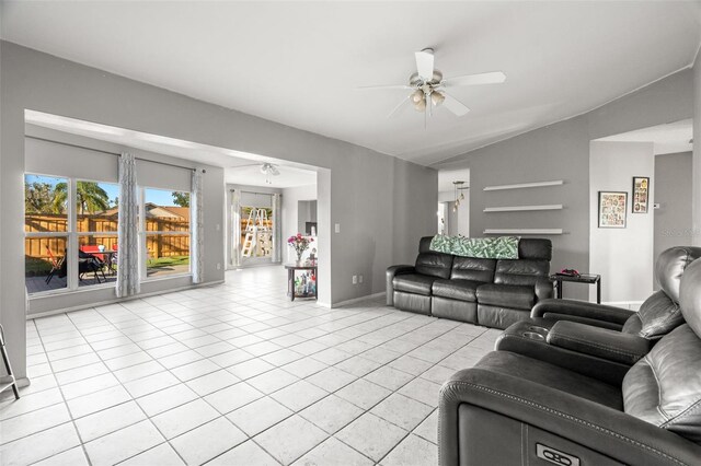 living room featuring lofted ceiling, ceiling fan, baseboards, and light tile patterned flooring