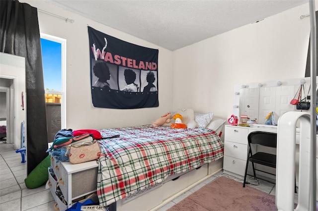 bedroom with a textured ceiling and light tile patterned floors