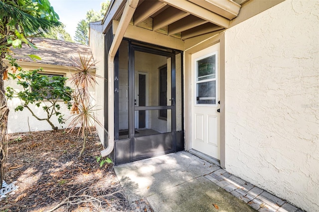 view of exterior entry with a patio