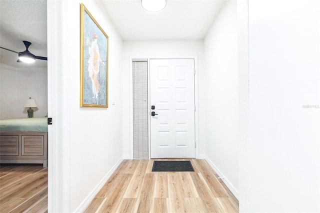 doorway featuring ceiling fan and light hardwood / wood-style floors