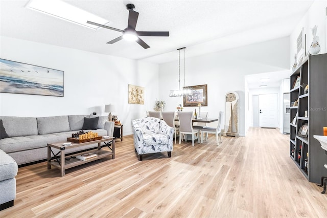 living room featuring hardwood / wood-style flooring, ceiling fan, a textured ceiling, and lofted ceiling