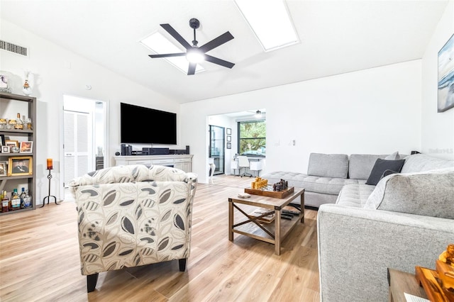 living room with ceiling fan, light wood-type flooring, and vaulted ceiling