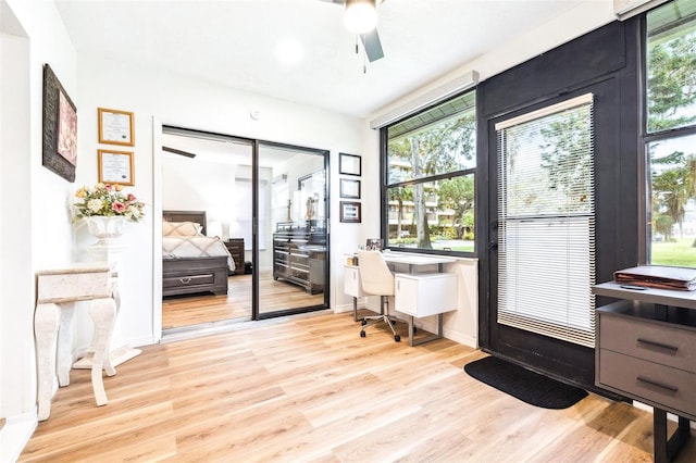 office space with light wood-type flooring, built in desk, and ceiling fan