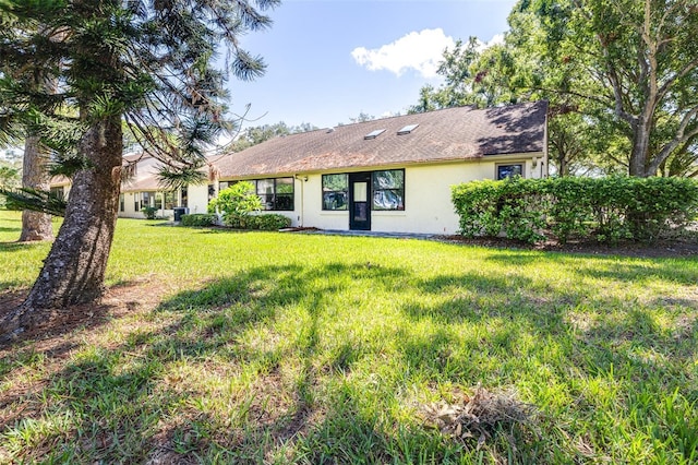 rear view of property featuring a lawn