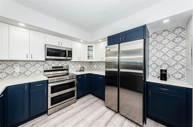 kitchen featuring blue cabinetry, stainless steel appliances, and light countertops