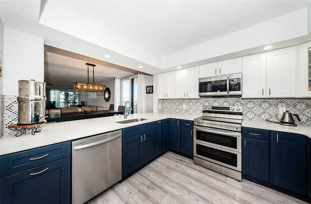 kitchen featuring a sink, light countertops, blue cabinetry, and stainless steel appliances