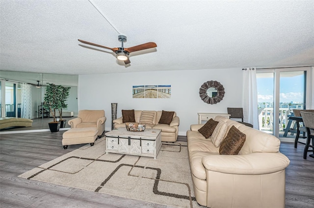 living room featuring a textured ceiling, a ceiling fan, and wood finished floors