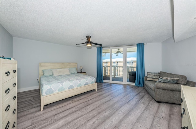 bedroom with access to exterior, a textured ceiling, light wood-type flooring, and a ceiling fan