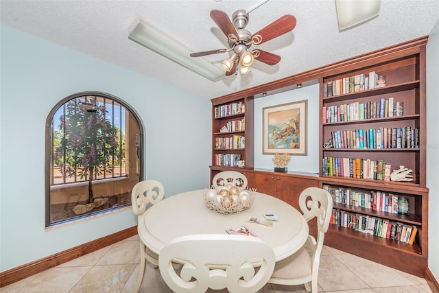 dining room featuring tile patterned flooring, baseboards, built in features, a textured ceiling, and a ceiling fan