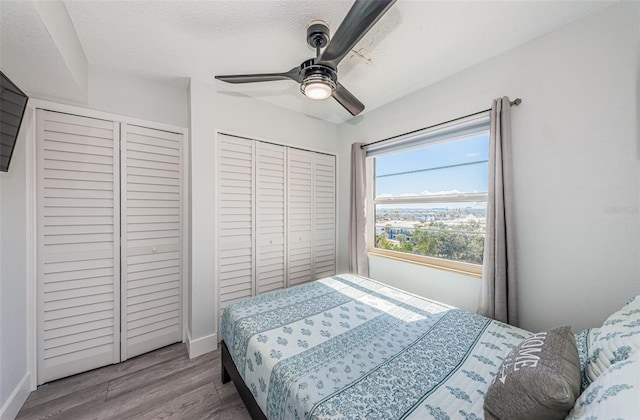 bedroom featuring a ceiling fan, wood finished floors, baseboards, and a textured ceiling