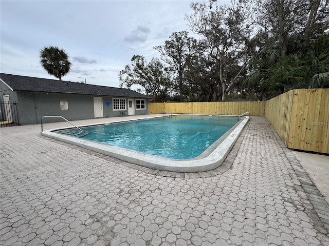 community pool with a patio and a fenced backyard