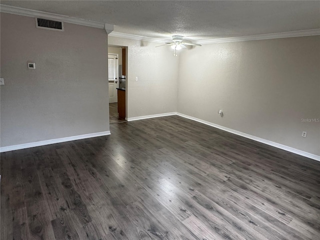 empty room featuring baseboards, visible vents, dark wood finished floors, a ceiling fan, and ornamental molding