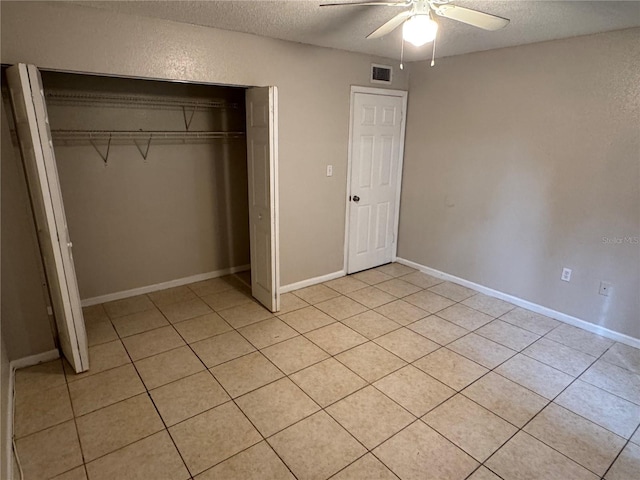 unfurnished bedroom featuring a textured ceiling, a closet, visible vents, and baseboards