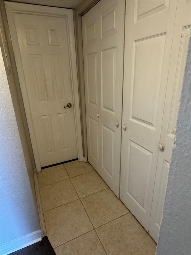 hall featuring light tile patterned flooring