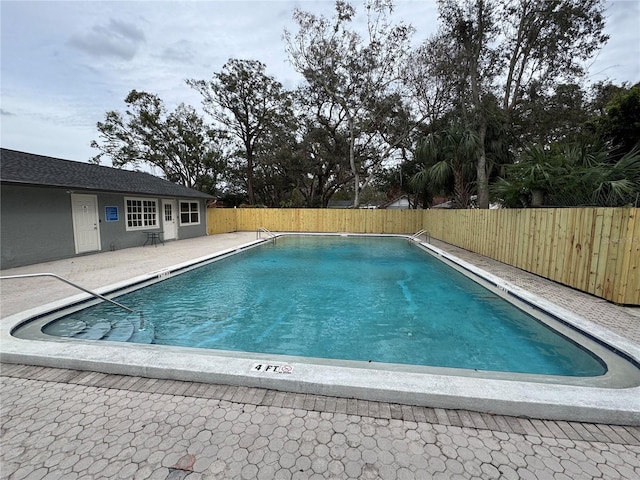 pool with a fenced backyard and a patio